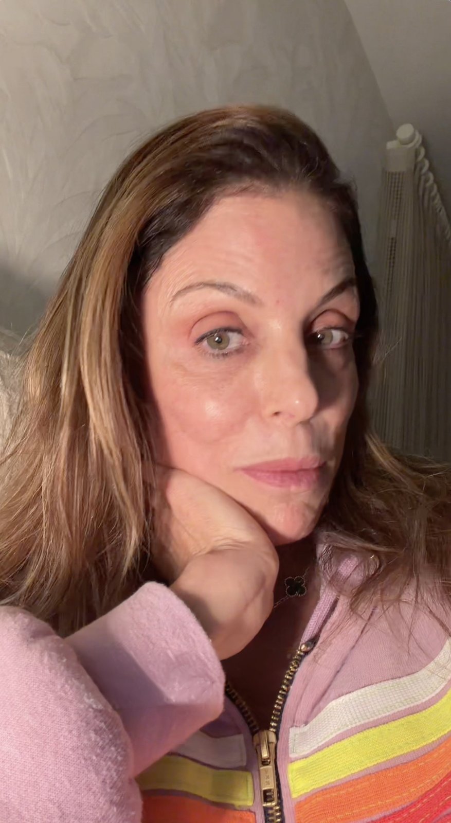 Bethenny Frankel rests her chin in her hand, looking seriously at the camera.